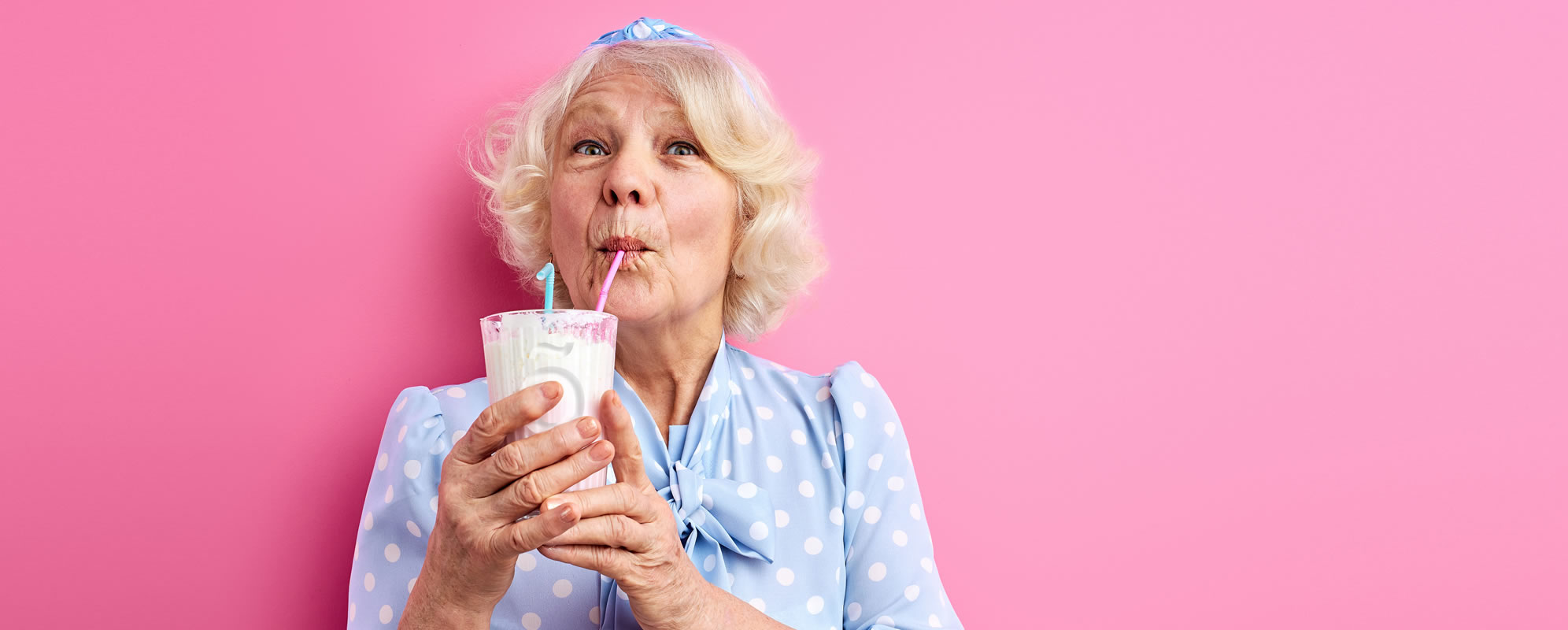 Lady enjoying a Slõ Milkshake thickening nutritional supplement. Dysphagia drinks thickeners.