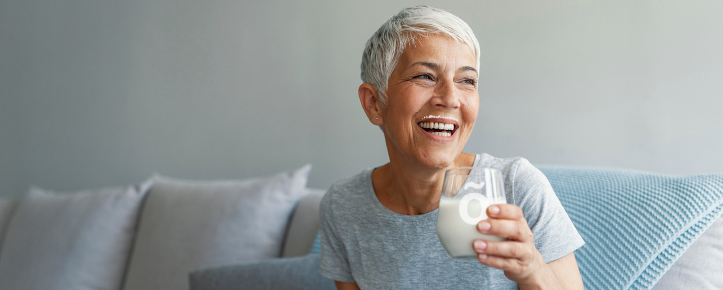 Lady enjoying cold milk thickened with Slõ Syrup.